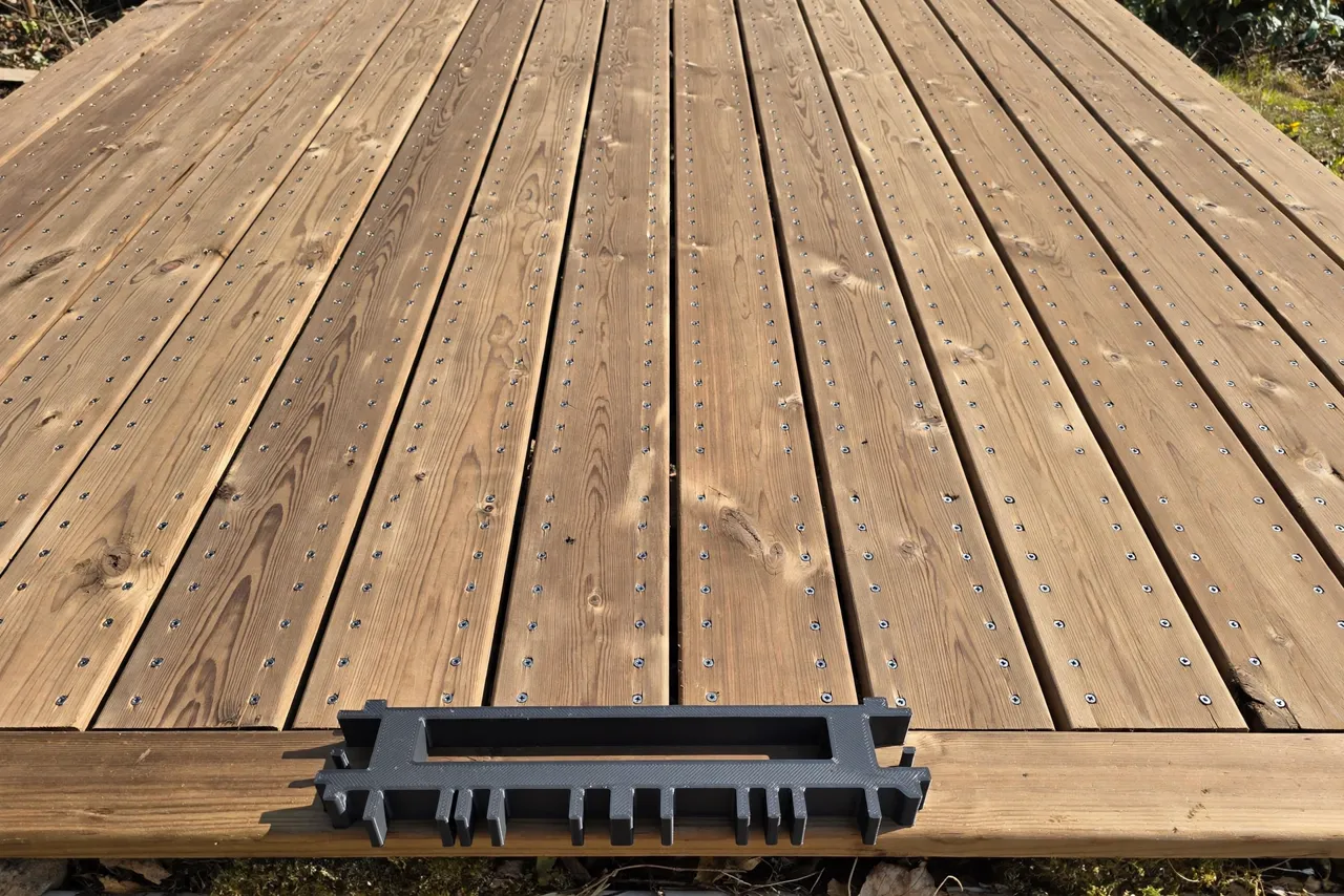 A finished deck surface with neat, evenly spaced rows of screws running across every board