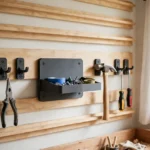 A bright home workshop wall with horizontal wooden French cleat rails