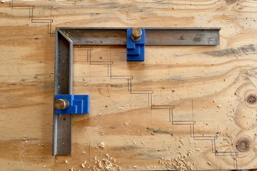 Top-down view of a framing square positioned on a wide pine board with two printed stair gauges set against its edges