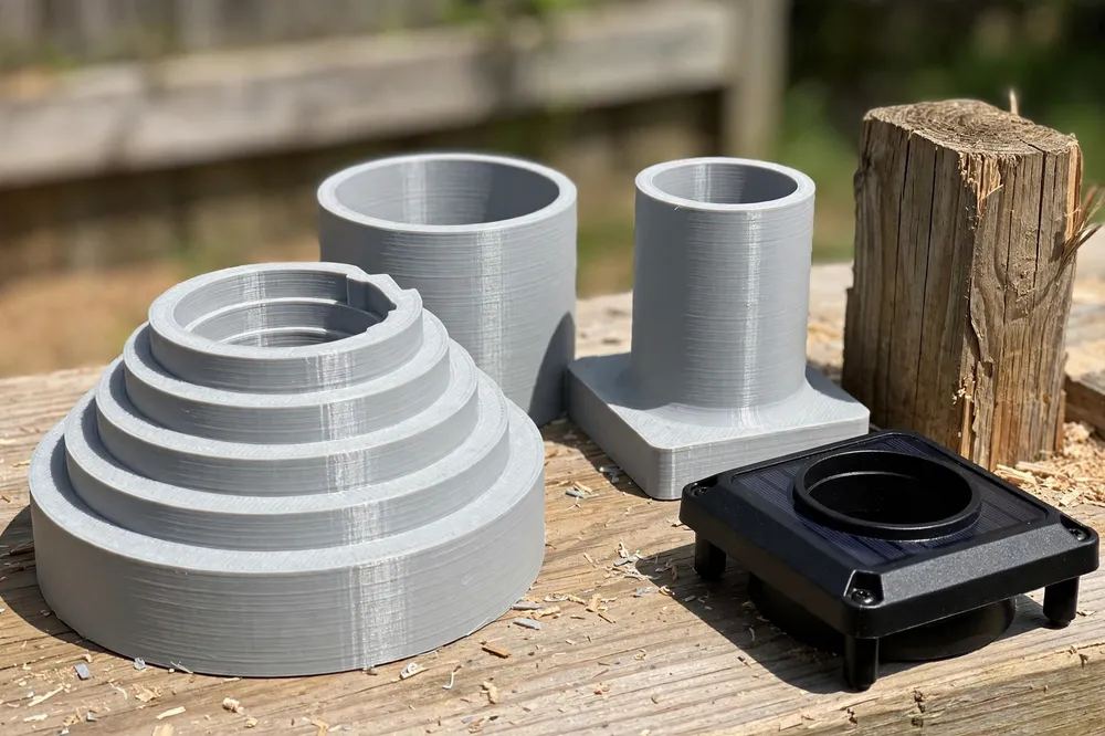 Close-up of a 3D printed adapter ring set on a workbench: a stepped reducer ring